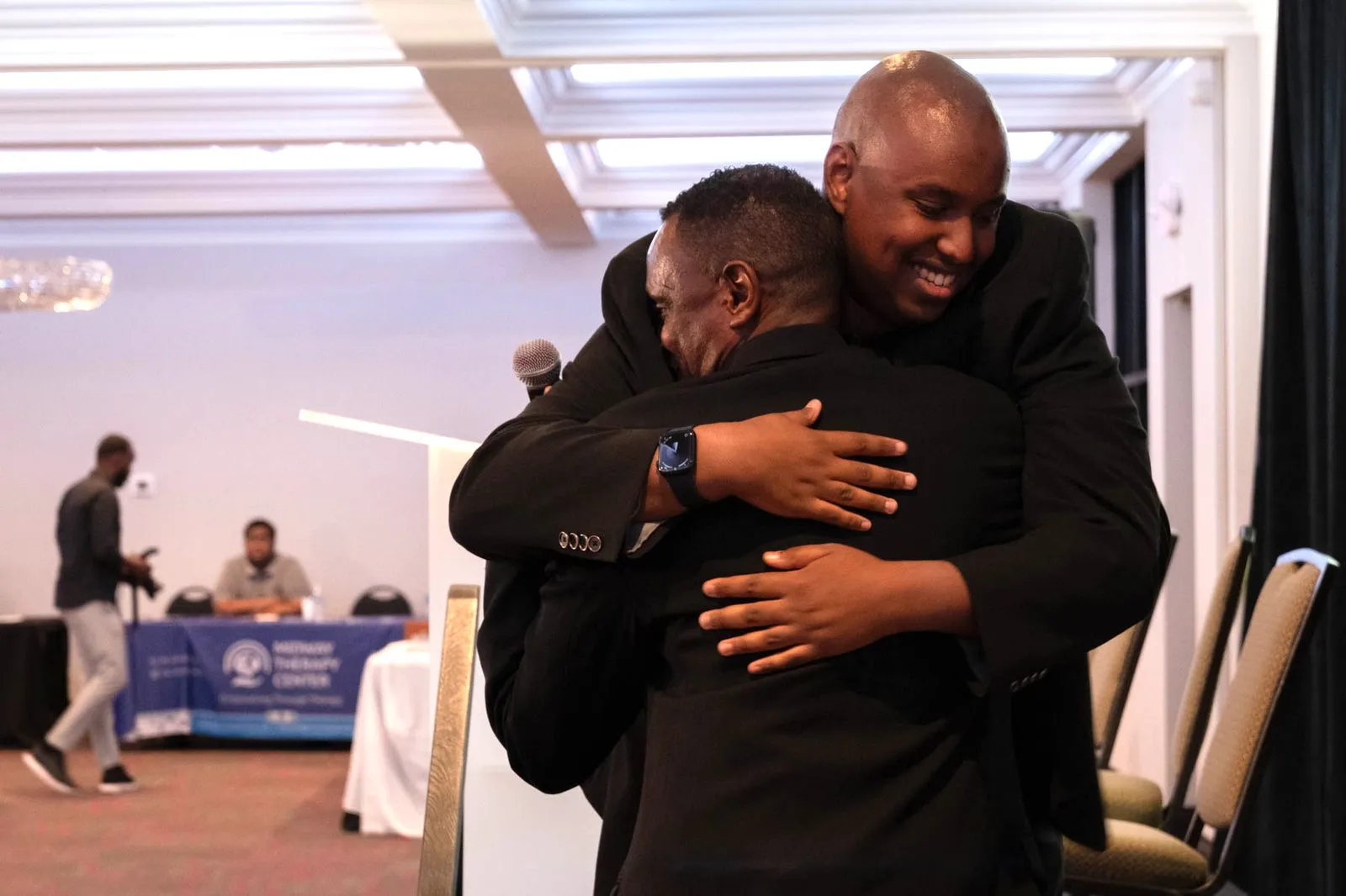 Two men share a warm embrace at Maangaar Summit 2025.