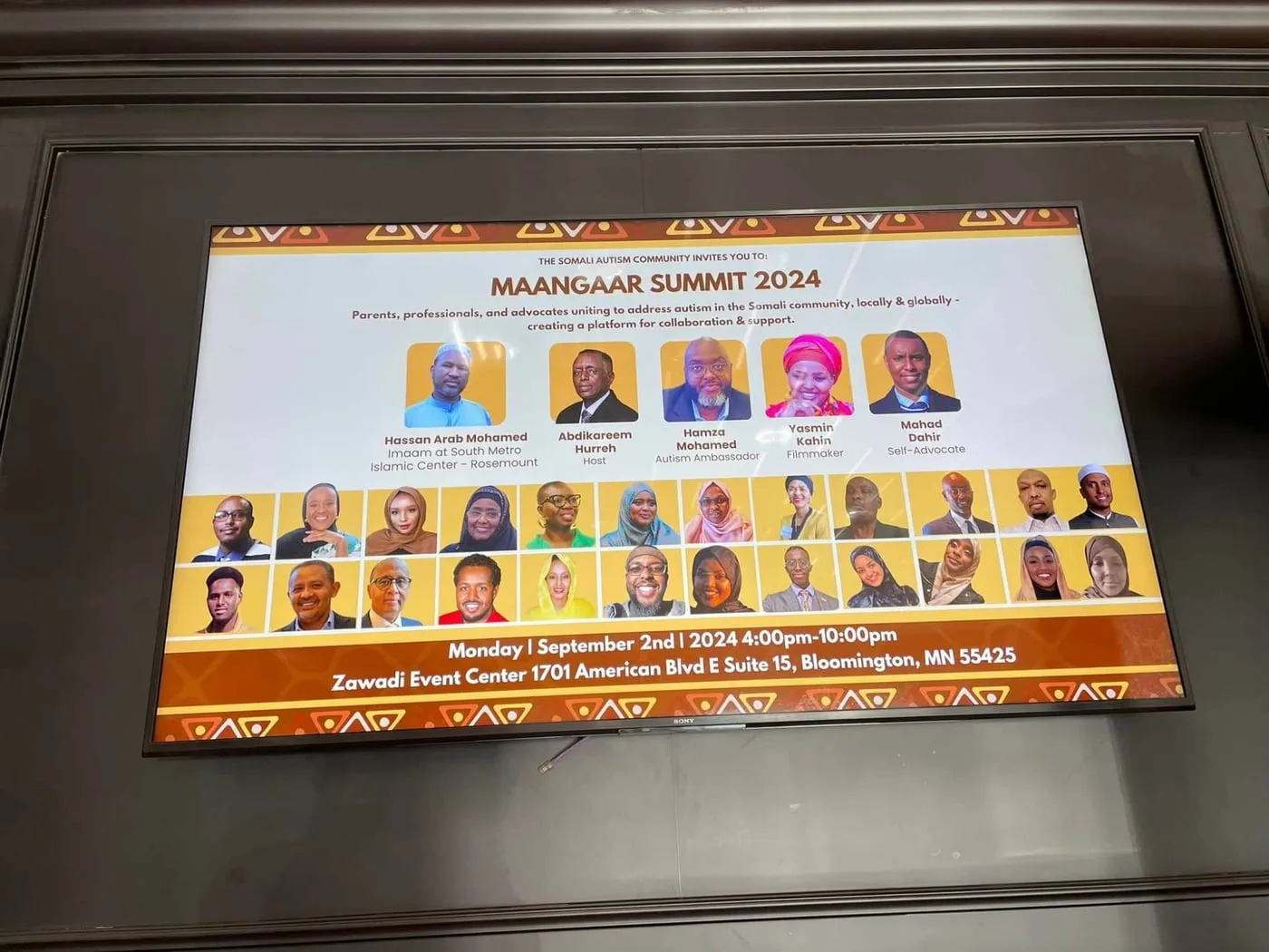 A screen at the venue shows the Maangaar Summit 2024 lineup: Hassan Arab Mohamed, Abdikareem Hurreh, Hamza Mohamed, Yasmin Kahin and Mahad Dahir, above portraits of the panelists.