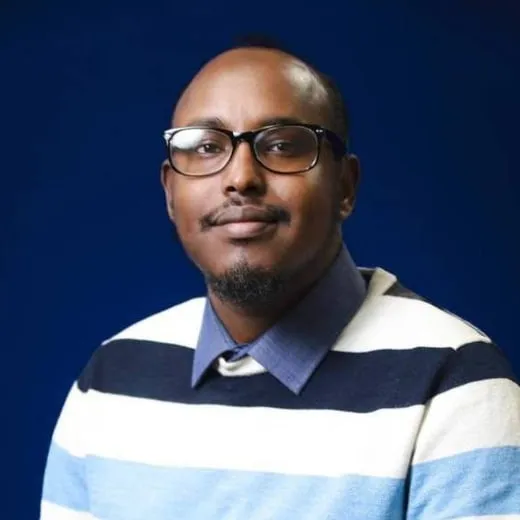 Portrait of Dr. Hussein Awjama in glasses and a striped sweater.