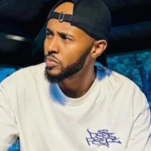 Portrait of Abwaan Khalid Haji Dek Dahir in a black cap and white T-shirt.