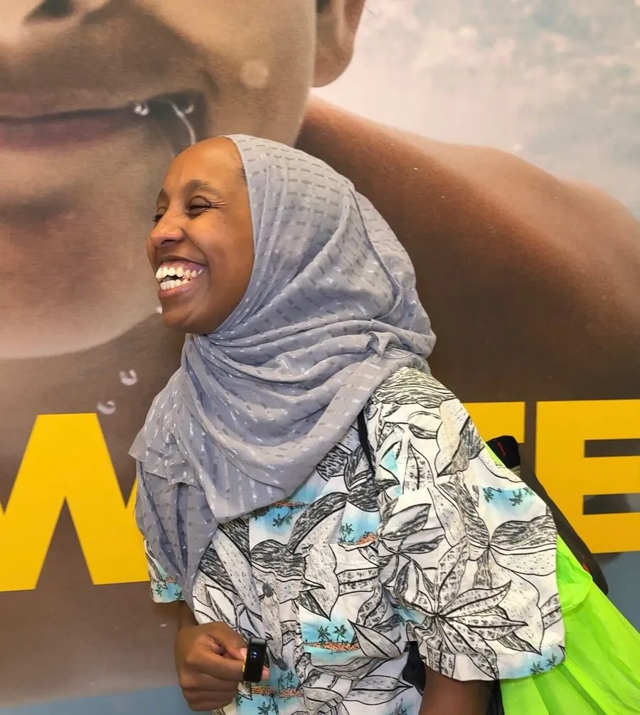 A smiling swim participant in a headscarf at the swim school.