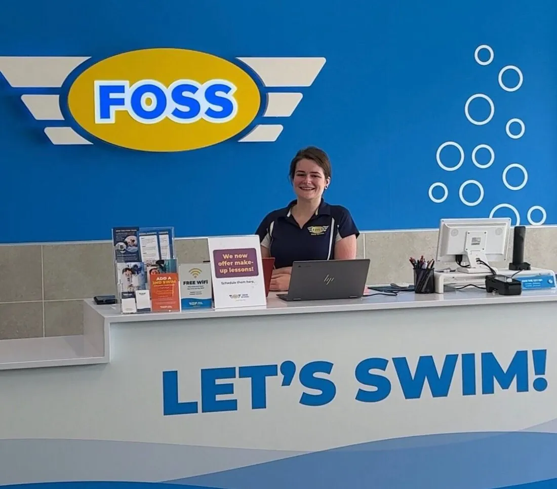 The FOSS Swim School front desk with a “Let’s Swim!” sign.