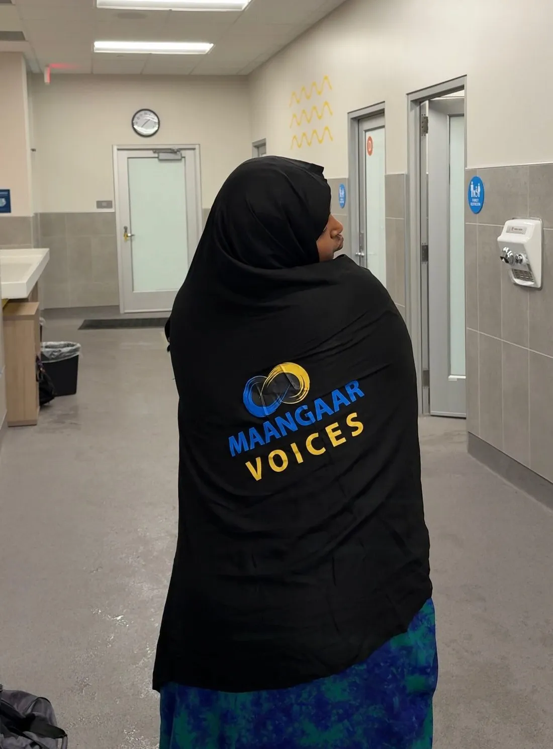 A participant wearing a Maangaar Voices hoodie walking toward the pool.