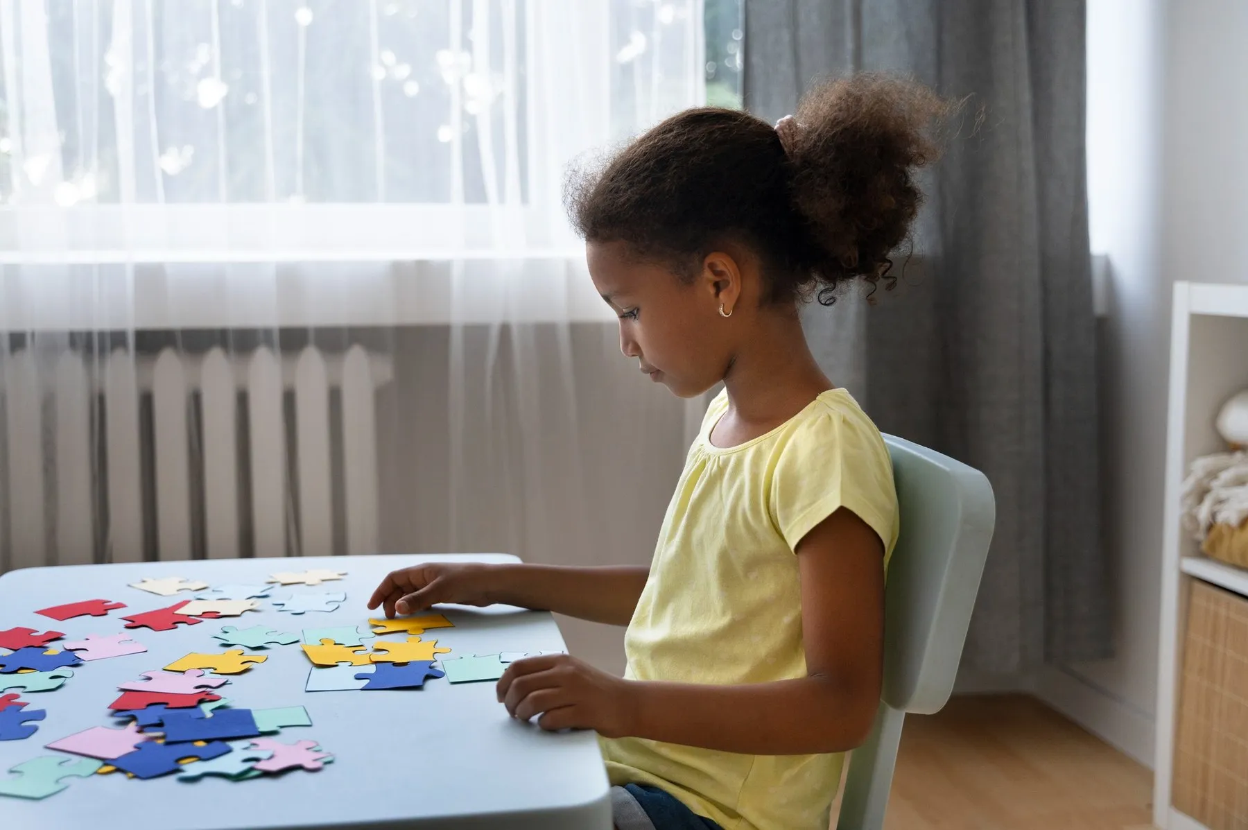 A child arranging colorful shapes at a table.